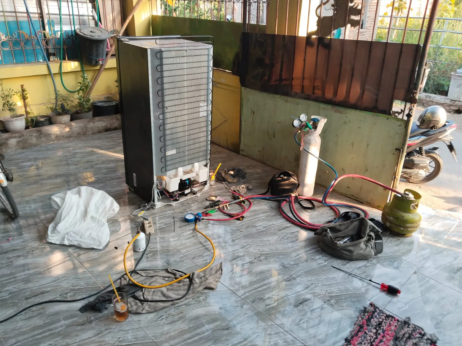 Teknisi Reparasi AC Surabaya sedang membersihkan unit AC
